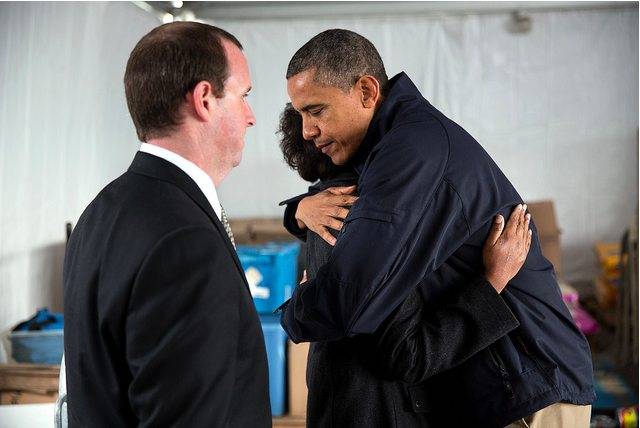 President Obama hugs Glenda Moore, with Damien Moore looking on, at a FEMA Disaster Recovery Center tent in Staten Island